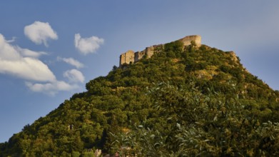 Byzantine castle of Mystras, rising on a wooded hill against the backdrop of a blue sky with