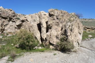 Rough rocky area with little vegetation and blue sky above, Stone Book, landscape near Dashtakar,