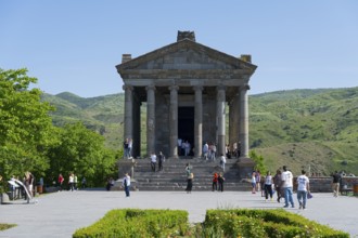 The temple design attracts tourists, surrounded by green, mountainous landscape, Greek-Roman Temple