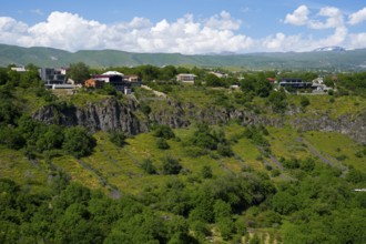 Hilly landscape with scattered houses and dense greenery under a blue sky, Garni Gorge, Azat River,