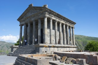 Ancient temple with columns and architectural details against a clear blue sky, Greek-Roman Temple