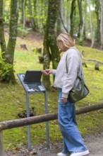 Woman reading an information board in a wooded area, Affenberg Salem, Lake Constance district,