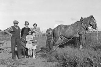 French farmer family with horse in the field, historical photograph from the 1970s, black and