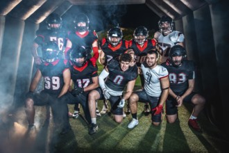 American football team poses united in helmets and pads, emerging from a smoky stadium tunnel under