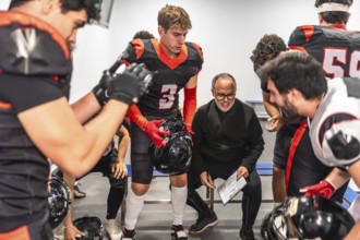 American football coach briefing players in a locker room, outlining strategy and tactics while