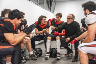 American football coach briefing players in a locker room, outlining strategy and motivating the