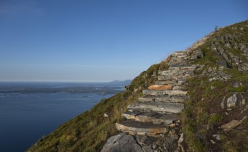 Woman walking up Rørsethornet stone stairs, with 3292 steps one of the longest continuous stone