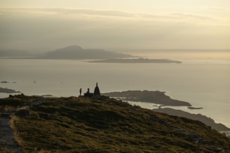 Woman standing next to cairn silhouette, Rørsethornet stone staircase, with 3292 steps one of the