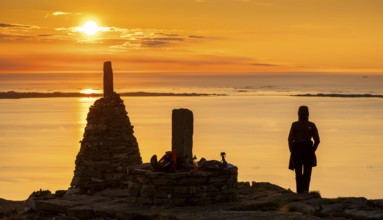 Silhouette of a woman watching the sunset next to cairns, Rørsethornet stone staircase, with 3292