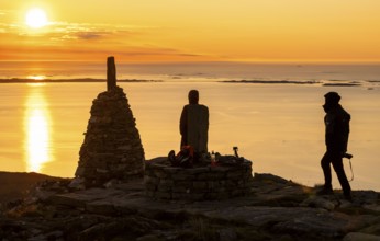 Silhouettes of two hikers next to cairns at sunset, Rørsethornet stone staircase, with 3292 steps