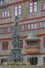 Neptune fountain with sculpture of Neptune Roman god of the sea with trident on the house facade
