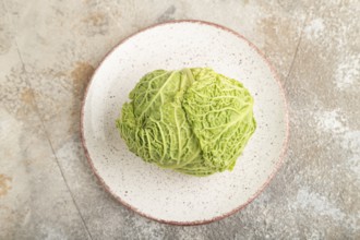 Green lettuce on plate on brown concrete background. Top view, copy space, flat lay. healthy food,