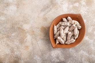 Small smoked Chicken sausages in clay bowl on brown concrete background. top view, copy space