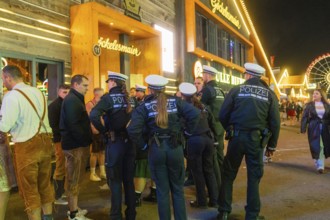 Police officers monitor the marquee area at night and ensure safety among the visitors, Cannstatter