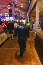 Security guard in a well-attended beer tent with festival decorations, Cannstatter Wasen folk