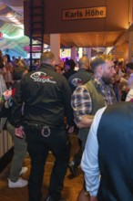 Security guards in a busy marquee during a party, Cannstatter Wasen folk festival, Stuttgart,