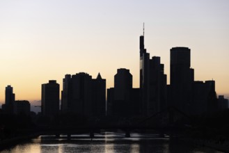 The silhouette of Frankfurt's banking skyline stands out against the backlight of the evening sun,