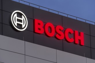 Bosch logo illuminated on the building façade against a blue night sky, Waiblingen,