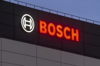 Illuminated Bosch logo on a grey façade against a blue night sky, Waiblingen, Baden-Württemberg,
