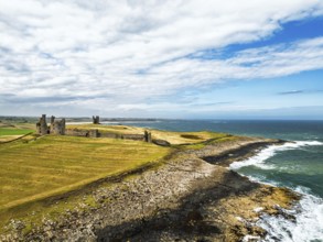 Dunstanburgh Castle from a drone, Northumberland Coast, England, United Kingdom