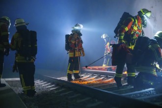 Firefighters working with equipment on tracks in a tunnel, firefighting exercise in the new