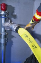 Fire hose being connected to hydrant, close-up of the connection, fire brigade exercise in the new