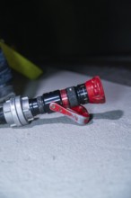 Close-up of a fire hose with a red nozzle on the ground, fire drill in the new construction tunnel