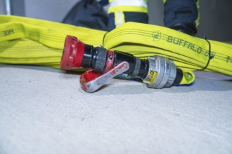 Fire hose with connected valve lying on the ground, emergency situation, firefighting exercise in
