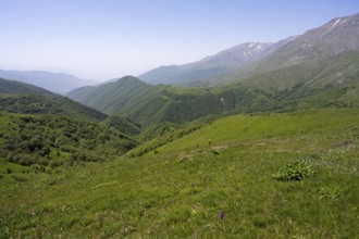 Green valley with hills and mountains under a wide sky, at the highest pass in Armenia, Meghri