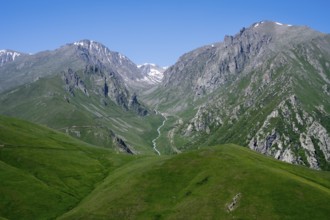 Green hills and a deep valley with mountains under a clear sky, at the highest pass in Armenia,