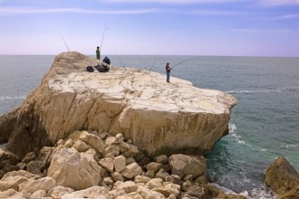 Angler, fishing, rocky plate, south at the rock Penon de Ifach landmark, Mediterranean Sea, bay,