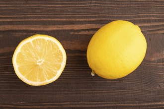 Yellow Lemon Cut in half on brown wooden background. Top view, flat lay, close up. healthy food,