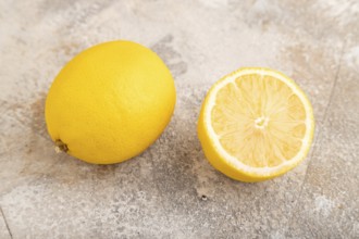 Yellow Lemon Cut in half on brown concrete background. Side view, close up, healthy food,