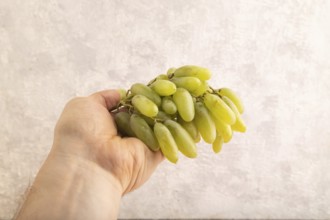 Green grapes on gray concrete background. Side view, copy space. healthy food, minimalism