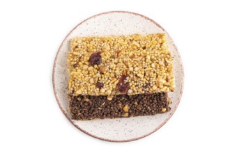 Granola bars with caramel, nuts, flakes in ceramic plate isolated on white background. Top view,