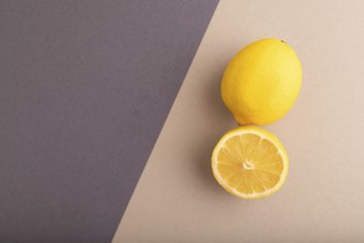 Yellow Lemon Cut in half on beige and gray pastel paper background. Top view, flat lay, copy space.