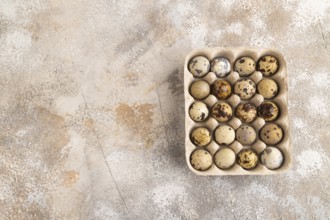 Pile of Raw Quail eggs on a brown concrete background. top view, flat lay, copy space