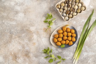 Pile of Smoked Quail eggs on plate on a brown concrete background. top view, flat lay, copy space