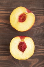 Peach Cut in half on brown wooden background. Top view, flat lay, close up. healthy food,