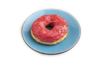 Pink Donut with sprinkles on blue ceramic plate isolated on white background, side view, close up,