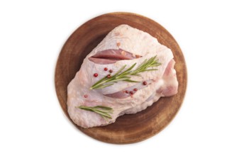 Raw Turkey Thigh with spices and rosemary on cutting board isolated on white background. top view,