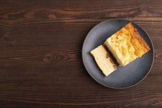 ?ottage cheese ?asserole, Curd cake, with dried apricots and raisins on brown wooden background,