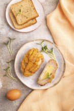 Chicken Schnitzel on blue plate with microgreen on brown concrete background and orange linen