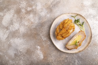 Chicken schnitzel on blue plate with microgreen on brown concrete. Diet, healthy eating. top view,