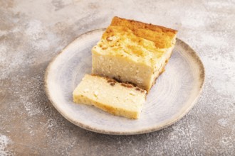 ?ottage cheese ?asserole, Curd cake, with dried apricots and raisins on brown concrete background,