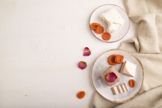 Cocoa and milk jelly with dried apricots on white wooden background and linen textile, top view,