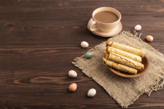 Waffles with caramel on brown wooden background and linen textile, cup of coffee, side view, Copy