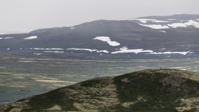 Vast mountain landscape with patches of snow and a cloudy atmosphere, pilgrimage route Olavsweg or