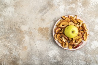 Dried Apples in ceramic bowl on brown concrete background. Top view, copy space, flat lay. healthy