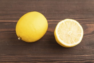 Yellow Lemon Cut in half on brown wooden background. Side view, close up. healthy food, vegetable,